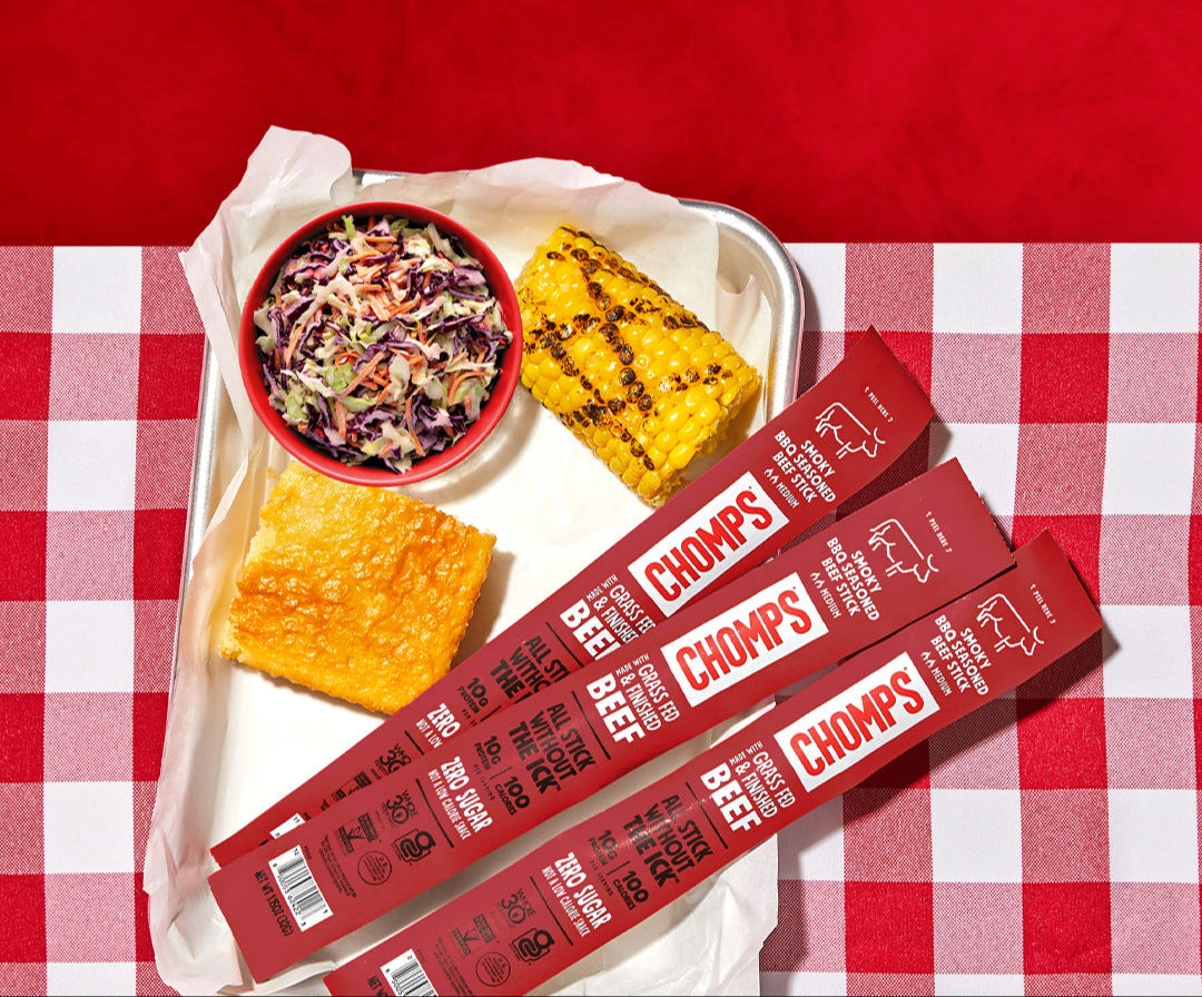 Smoky BBQ Chomps is back! An image of Smoky BBQ Chomps on a picnic table with corn and coleslaw.